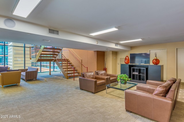 carpeted living area with stairway and visible vents