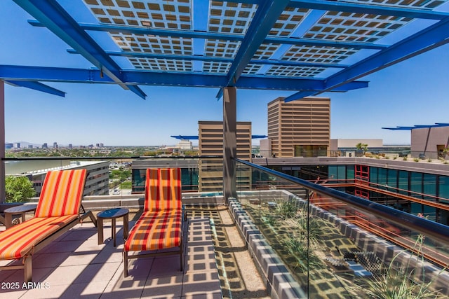 view of patio / terrace featuring a water view, a balcony, a pergola, and a city view