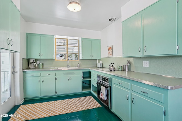 805 E Jackson Ave, Buckeye, AZ 85326 - kitchen featuring black oven, light countertops, a sink, and cooktop