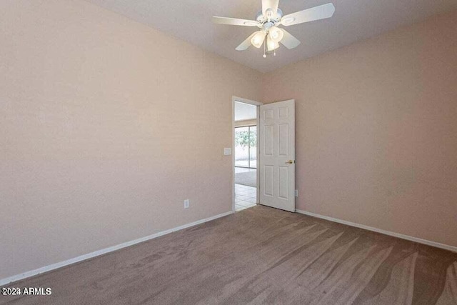 unfurnished room with ceiling fan and carpet