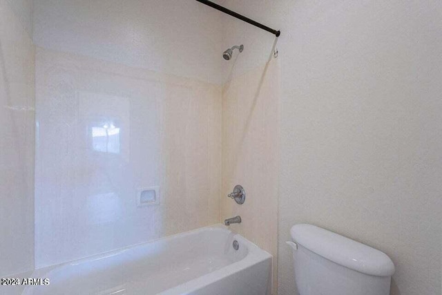 bathroom featuring toilet and tiled shower / bath