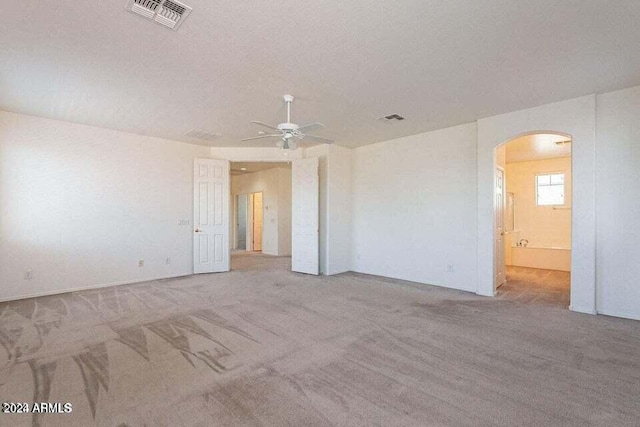 empty room featuring ceiling fan, light colored carpet, and a textured ceiling