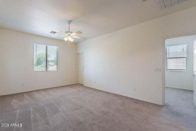 carpeted empty room with plenty of natural light, ceiling fan, and a textured ceiling