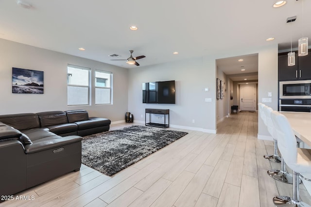 living room with visible vents, baseboards, recessed lighting, light wood-style floors, and a ceiling fan