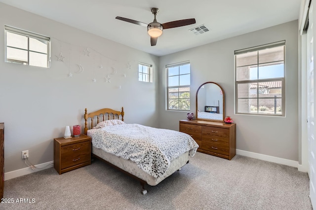 bedroom with ceiling fan, baseboards, visible vents, and light carpet