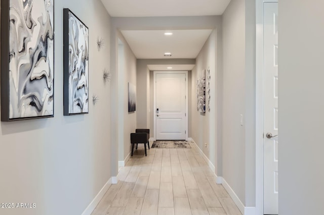 hall featuring baseboards and light wood finished floors