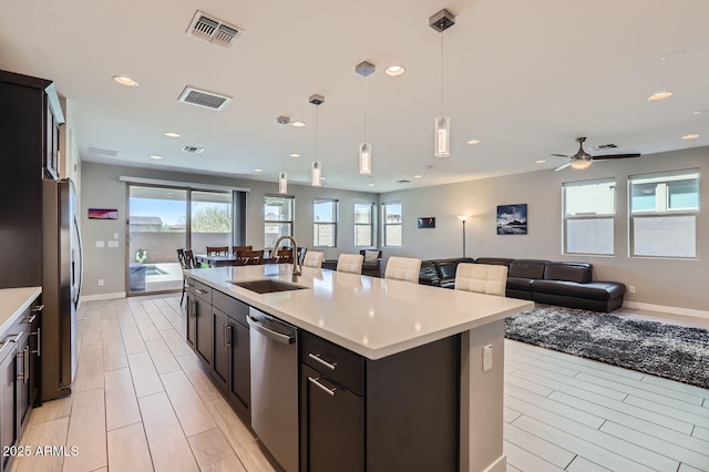 kitchen featuring visible vents, appliances with stainless steel finishes, open floor plan, and a sink