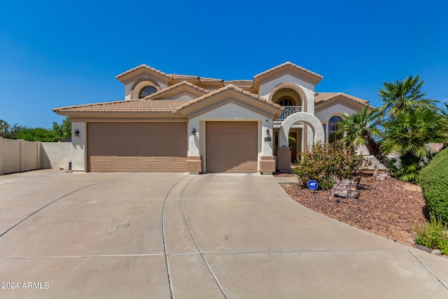 mediterranean / spanish-style home with a tiled roof, stucco siding, an attached garage, and concrete driveway