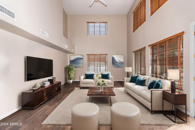 living room featuring a towering ceiling and dark hardwood / wood-style floors