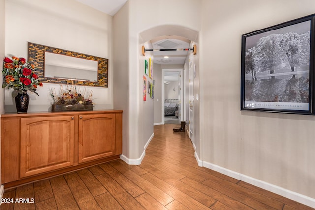 corridor with baseboards and wood finished floors