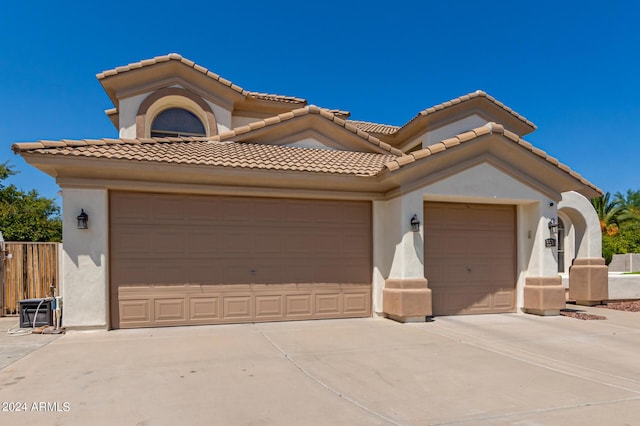 mediterranean / spanish house featuring stucco siding, driveway, and a garage