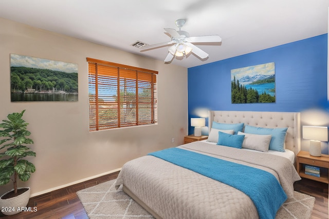 bedroom featuring visible vents, a ceiling fan, baseboards, and wood finished floors