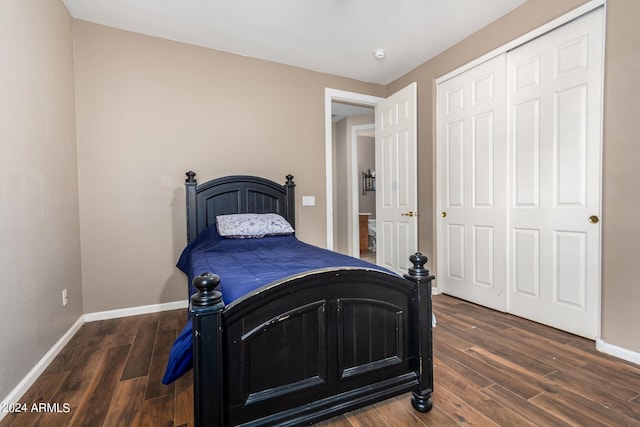 bedroom with dark hardwood / wood-style flooring and a closet