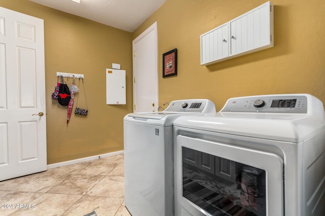 laundry area with laundry area, light tile patterned floors, baseboards, and washer and clothes dryer