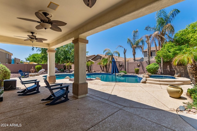 view of swimming pool with a patio, a fenced backyard, a pool with connected hot tub, and ceiling fan