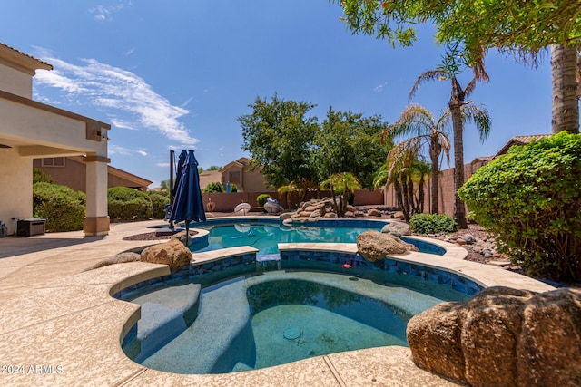 view of swimming pool with a patio, a fenced backyard, and a pool with connected hot tub