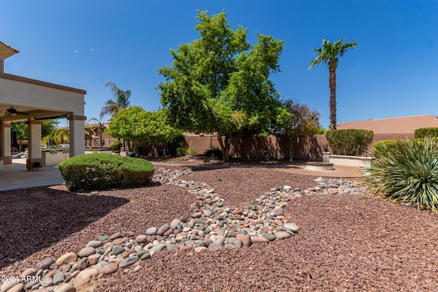 view of yard featuring a patio, a ceiling fan, and fence