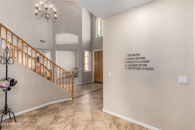 entrance foyer featuring tile patterned flooring, a chandelier, and a towering ceiling