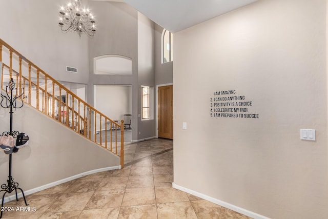 foyer featuring visible vents, baseboards, a notable chandelier, and stairs