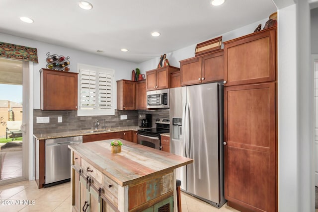 kitchen featuring light tile patterned floors, appliances with stainless steel finishes, a sink, wooden counters, and backsplash