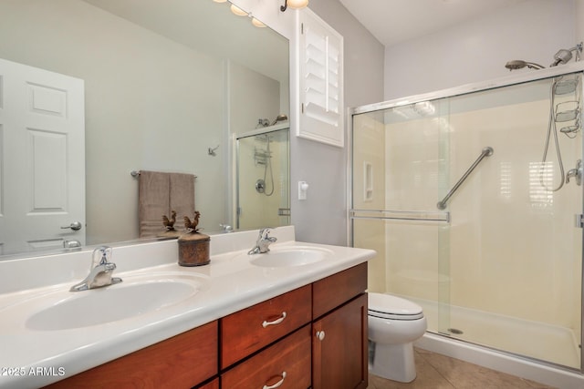 full bathroom featuring a sink, a shower stall, toilet, and tile patterned floors