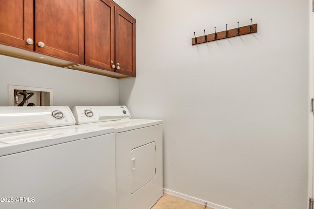 laundry room featuring cabinet space, washer and clothes dryer, baseboards, and light tile patterned floors