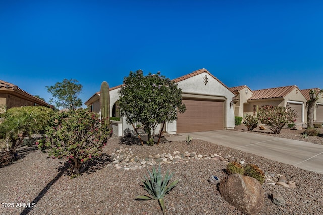 mediterranean / spanish-style house featuring a garage, concrete driveway, a tile roof, and stucco siding