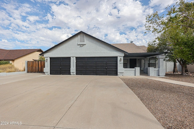 ranch-style house with a garage, concrete driveway, fence, and stucco siding