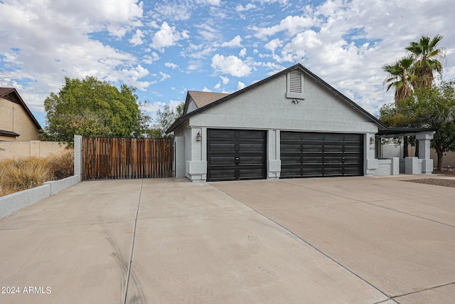 garage featuring driveway and fence