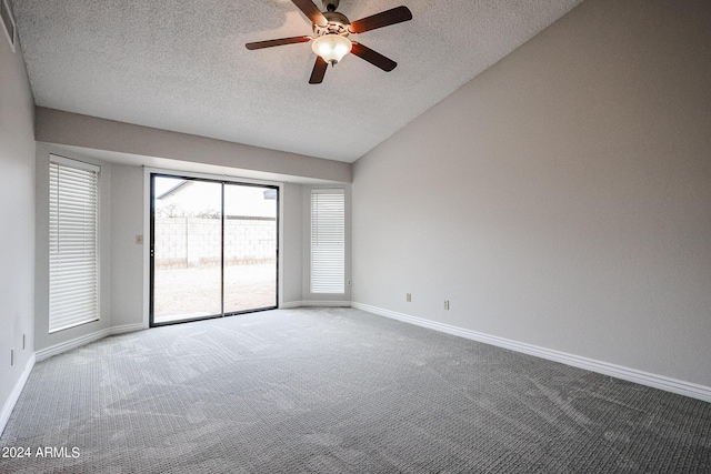 carpeted spare room with a textured ceiling, ceiling fan, vaulted ceiling, and baseboards