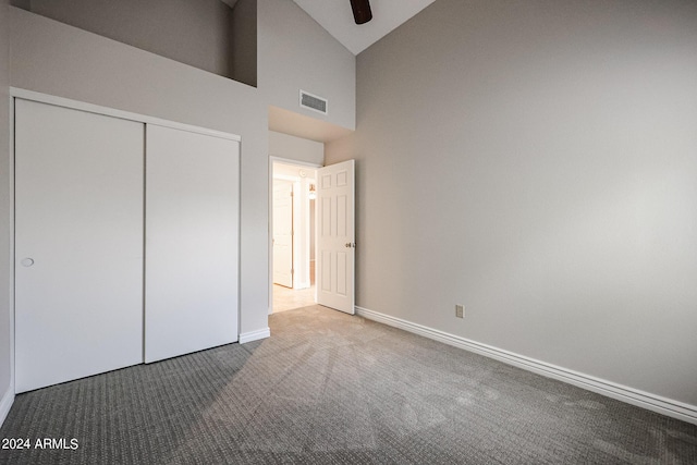 unfurnished bedroom with high vaulted ceiling, visible vents, baseboards, a closet, and carpet