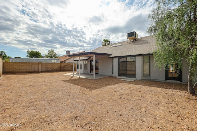 back of property featuring a shingled roof, a fenced backyard, a patio, and central air condition unit