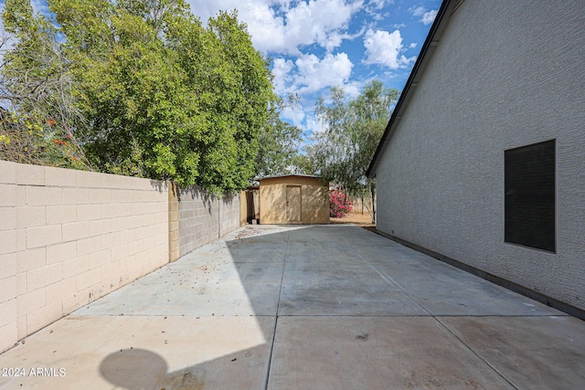 exterior space featuring a fenced backyard, a storage unit, and an outbuilding