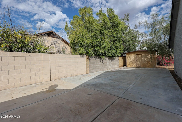 view of patio / terrace featuring a fenced backyard, an outdoor structure, and a shed