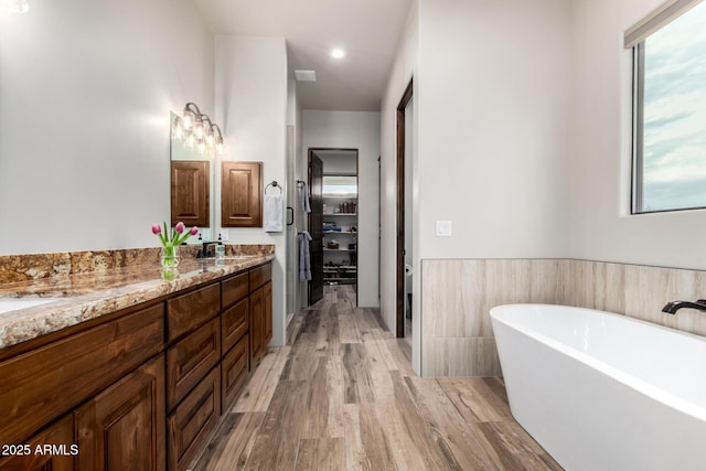 22050 W El Grande Trl, Wickenburg, AZ 85390 - full bath featuring a freestanding bath, wood finished floors, double vanity, and a healthy amount of sunlight