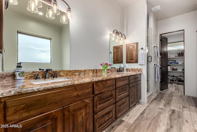 22050 W El Grande Trl, Wickenburg, AZ 85390 - full bathroom featuring a shower stall, a chandelier, wood finished floors, a sink, and double vanity