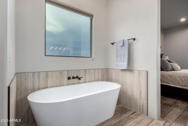 22050 W El Grande Trl, Wickenburg, AZ 85390 - bathroom with a freestanding tub, ensuite bathroom, wood finished floors, and tile walls