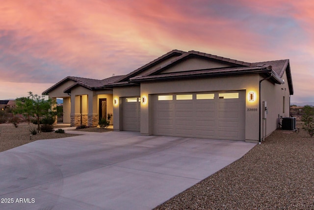 22050 W El Grande Trl, Wickenburg, AZ 85390 - view of front of home featuring an attached garage, concrete driveway, and stucco siding