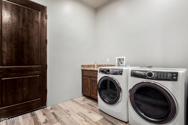 22050 W El Grande Trl, Wickenburg, AZ 85390 - washroom featuring light wood-style flooring, washer and clothes dryer, and cabinet space
