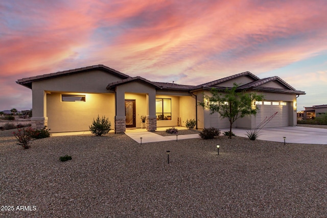 22050 W El Grande Trl, Wickenburg, AZ 85390 - ranch-style house featuring stone siding, a garage, a tile roof, concrete driveway, and stucco siding