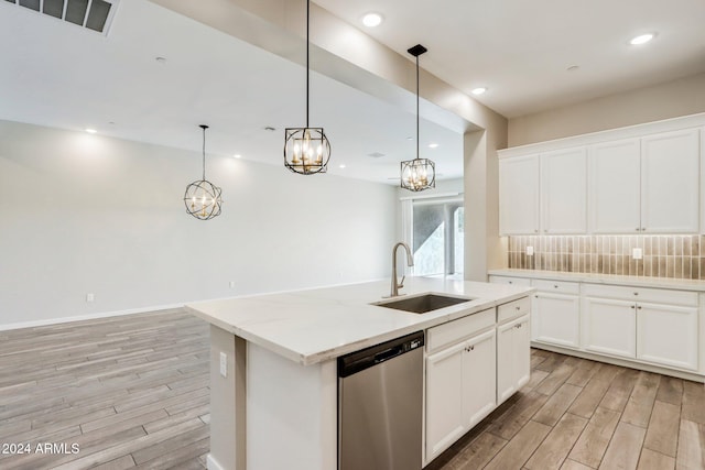 kitchen with stainless steel dishwasher, white cabinetry, sink, and a kitchen island with sink