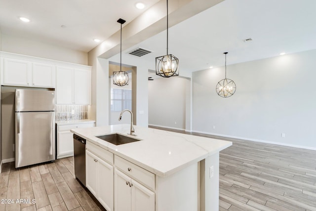 kitchen featuring a kitchen island with sink, sink, light wood-type flooring, and appliances with stainless steel finishes