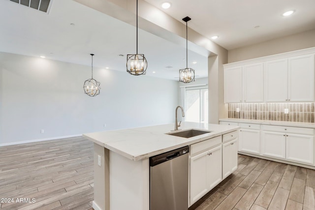 kitchen featuring white cabinets, sink, an island with sink, and stainless steel dishwasher