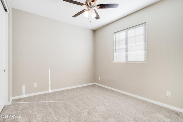 empty room featuring ceiling fan and light colored carpet