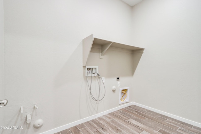 laundry room with hookup for an electric dryer, hookup for a washing machine, light hardwood / wood-style flooring, and hookup for a gas dryer