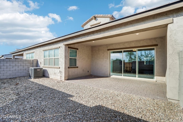 rear view of house with central AC unit and a patio area