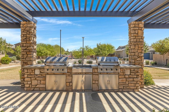 view of patio / terrace with a pergola, area for grilling, and exterior kitchen