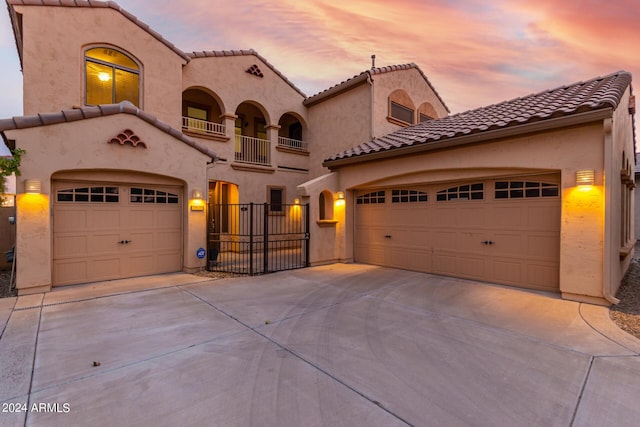 mediterranean / spanish home featuring a garage and a balcony