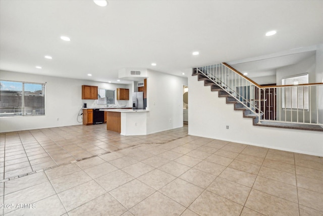 unfurnished living room featuring a healthy amount of sunlight and light tile patterned floors