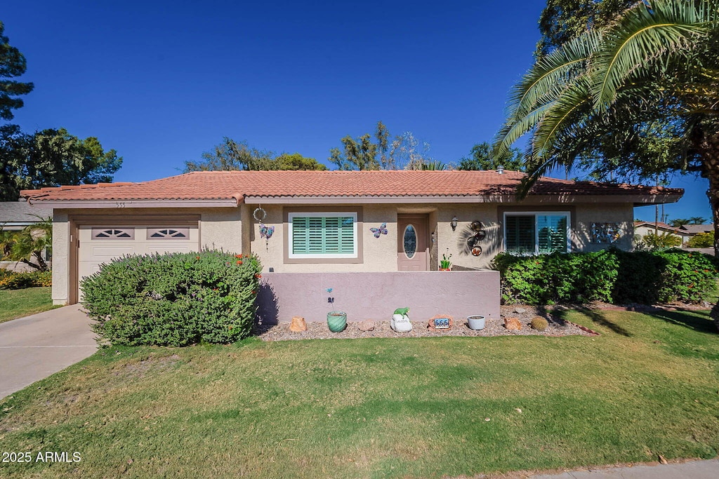 ranch-style home with a garage, stucco siding, a tile roof, and a front yard